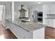 Modern kitchen features granite countertops, stainless steel appliances, white cabinetry and hardwood flooring at 3725 Crescent Walk Ln, Suwanee, GA 30024
