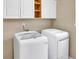 Convenient laundry room equipped with modern washer and dryer, ample storage, and bright lighting at 3725 Crescent Walk Ln, Suwanee, GA 30024