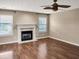 Comfortable living room features a fireplace, large windows, and hardwood floors, a perfect relaxing space at 3725 Crescent Walk Ln, Suwanee, GA 30024