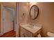 Half bath with a modern single vanity, round mirror, and wood floors at 1622 Rivergreen Se Bnd # 26, Atlanta, GA 30339