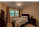 Bedroom with neutral walls, carpet floors, a window for natural light, and a tv on a dresser at 1622 Rivergreen Se Bnd # 26, Atlanta, GA 30339