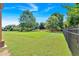 Well-maintained backyard with a freshly mowed lawn, mature trees, and fenced perimeter, providing privacy and security at 3819 Courson St, Marietta, GA 30066