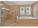 Bathroom showcasing soaking tub, glass enclosed shower, and tile floors at 3819 Courson St, Marietta, GA 30066