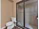 Bathroom showcasing a toilet and a glass enclosed shower with light beige tiling and mosaic accents at 3819 Courson St, Marietta, GA 30066