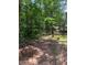 Wooded property with a path and a mobile home in the background offering potential building sites at 6394 Shore Dr, Douglasville, GA 30135