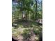A red barn with gray roof is nestled on a lush lot, with wooded surroundings at 6394 Shore Dr, Douglasville, GA 30135