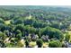 Expansive aerial view of a residential neighborhood with lush green trees and well-maintained houses in a suburban setting at 1313 Fallsbrook Nw Ter, Acworth, GA 30101
