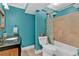 A vibrant bathroom featuring blue walls, a shower-tub combo, and a marble-top vanity at 1313 Fallsbrook Nw Ter, Acworth, GA 30101