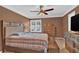 Bedroom with a plaid bedspread, ceiling fan, window, and wooden furniture at 1313 Fallsbrook Nw Ter, Acworth, GA 30101