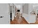 Hallway displaying gleaming hardwood floors. It provides access to the living room and kitchen at 1313 Fallsbrook Nw Ter, Acworth, GA 30101