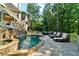 Backyard oasis with a luxurious pool, hot tub, lounge chairs, waterfall, and private wooded views at 1313 Fallsbrook Nw Ter, Acworth, GA 30101