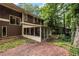 Back view of the house with a brick patio and screened-in porch at 4968 Twin Branches Way, Dunwoody, GA 30338