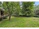 Serene backyard featuring lush green lawn and wooded backdrop at 4968 Twin Branches Way, Dunwoody, GA 30338