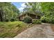 Side view of property featuring mature trees and manicured lawn at 4968 Twin Branches Way, Dunwoody, GA 30338