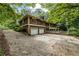 Rear exterior featuring a two-car garage and ample parking space at 4968 Twin Branches Way, Dunwoody, GA 30338