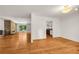 Open-concept living space with hardwood floors, a brick fireplace, and access to the kitchen at 4968 Twin Branches Way, Dunwoody, GA 30338