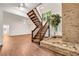 The wooden staircase with brick accent wall is bathed in natural light from nearby window at 4968 Twin Branches Way, Dunwoody, GA 30338