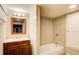 Well-lit bathroom with vanity, mirror, combination tub and shower with tile surround at 504 N Little Victoria Rd, Woodstock, GA 30189