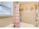 Bathroom with tiled shower-tub, patterned curtain, and window at 504 N Little Victoria Rd, Woodstock, GA 30189