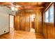Bedroom with wood paneling, hardwood floors, ceiling fan, and a doorway that leads to the bathroom at 504 N Little Victoria Rd, Woodstock, GA 30189
