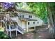Back exterior of this two-story home featuring a covered porch and lush surroundings at 504 N Little Victoria Rd, Woodstock, GA 30189