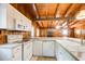Functional kitchen with white appliances, wood-paneled walls, and serving bar at 504 N Little Victoria Rd, Woodstock, GA 30189