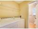 Laundry room with washer, dryer, shelving, and doorway to bathroom at 504 N Little Victoria Rd, Woodstock, GA 30189