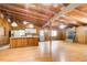 Open-concept living room with wood-paneled walls and wood floors flows to kitchen with breakfast bar and fireplace at 504 N Little Victoria Rd, Woodstock, GA 30189