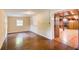 Living room featuring wood floors, beige walls and wooden doorway to another room with wood paneled walls and fireplace at 504 N Little Victoria Rd, Woodstock, GA 30189