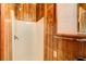 Bathroom with wooden paneled walls, white shower stall with glass door, and shower head at 504 N Little Victoria Rd, Woodstock, GA 30189
