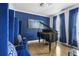 Elegant living room showcasing a grand piano, blue velvet seating, and stylish blue accent wall at 1165 Laurel Se Pl, Smyrna, GA 30080