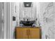 Stylish powder room featuring marble walls, unique vessel sink, and modern fixtures at 1165 Laurel Se Pl, Smyrna, GA 30080