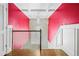 Bright staircase with modern chandelier, rich hardwood floors, and pink accent wall at 1165 Laurel Se Pl, Smyrna, GA 30080
