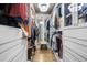 Bright walk-in closet with custom shelving, mirrored walls, and decorative lighting for ample storage at 1165 Laurel Se Pl, Smyrna, GA 30080