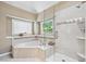 Elegant bathroom featuring a tiled shower, soaking tub, and a window offering natural light at 1297 Hadaway Trl, Lawrenceville, GA 30043