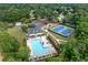 Aerial view of the community pool, tennis courts, playground, and parking area surrounded by trees at 1297 Hadaway Trl, Lawrenceville, GA 30043