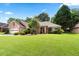 Charming single-story brick home featuring an attached garage, mature trees, and a well-manicured lawn at 1297 Hadaway Trl, Lawrenceville, GA 30043