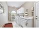 Well-lit laundry room with washer, dryer, white cabinets, sink, window, and tile flooring at 1297 Hadaway Trl, Lawrenceville, GA 30043