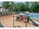 View of a playground with swings and a slide next to tennis courts and mature trees at 1297 Hadaway Trl, Lawrenceville, GA 30043