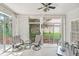 Bright sunroom has large windows, a ceiling fan, and comfortable seating to enjoy backyard views at 1297 Hadaway Trl, Lawrenceville, GA 30043
