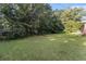 Exterior backyard with the lawn surrounded by lush trees at 3953 Dalhouise Ln, Decatur, GA 30034