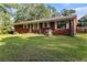 View of the house from the backyard, showing the lawn and mature trees at 3953 Dalhouise Ln, Decatur, GA 30034