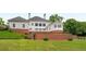 An eye-level shot of backyard with brick retaining walls, green grass, and mature trees beyond at 833 Hines Rd, Moreland, GA 30259