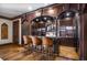 Custom bar area with ornate wood details, a countertop, shelving, and seating for entertaining at 833 Hines Rd, Moreland, GA 30259