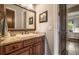 Bathroom with granite countertops, dark wood cabinets, decorative mirror, and an opening to the bedroom at 833 Hines Rd, Moreland, GA 30259
