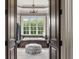 Elegant bathroom featuring a soaking tub with view, marble counters, and an ottoman at 833 Hines Rd, Moreland, GA 30259