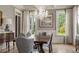 Beautiful dining room with chandelier, hardwood floors, wainscoting, and large windows that provide natural light at 833 Hines Rd, Moreland, GA 30259