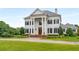 Elegant white home showcases prominent columns and meticulously manicured front yard at 833 Hines Rd, Moreland, GA 30259