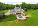 Aerial view of a stunning pool with lounge area, brick retaining wall, and mature landscaping at 833 Hines Rd, Moreland, GA 30259