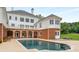 Stunning pool view with brick accents and white exterior detailing provides resort-style relaxation at 833 Hines Rd, Moreland, GA 30259